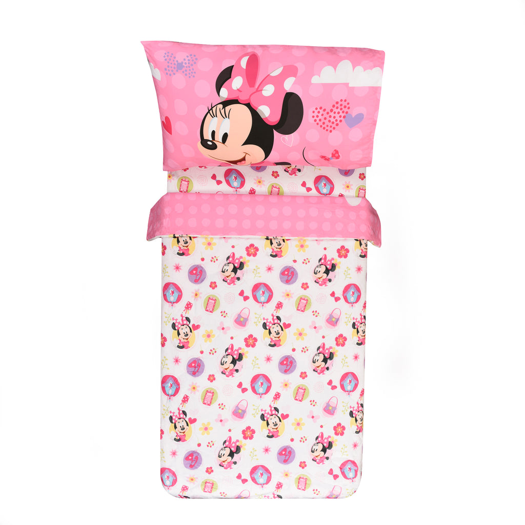 Disney Minnie Mouse Toddler Bedding Set reversed comforter on a bed on white background