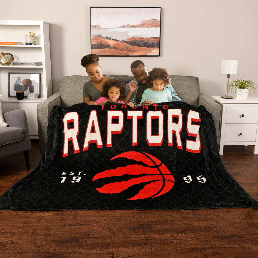 NBA Toronto Raptors Arena Blanket with models on couch